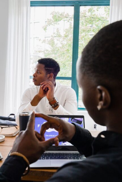 Black professionals discussing a brief — illustrative stock photograph