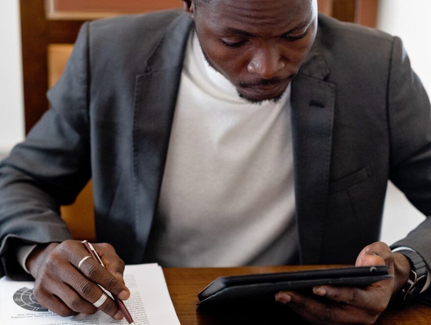 Man Sitting at the Desk with a Tablet and Documents — illustrative stock photograph